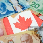 Close up of Canadian flag on dollar banknotes.