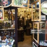 An antique store with old paintings, mirrors, furniture, lamps and statues