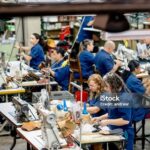 Group of Latin American manual workers working at a shoe-making factory