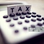 Calculator with the word tax written in wooden block letters
