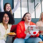 Group of girls teenager watching women's soccer football match championship