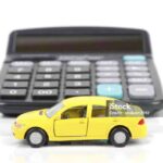 Toy car and calculator on white background