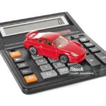 Calculator and red toy car isolated on white background
