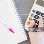 Hand with calculator and notepad, stock photo