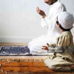 Little boy praying alongside his father during Ramadan