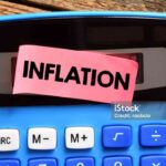 The word INFLATION on a small piece of paper lying on the calculator.