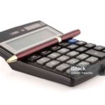 black calculator and a red pen on a white