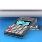Calculator with pencil lies on blueprint