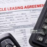 Automobile lease agreement document with key and pen on contract