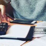 Man using calculator and calculate bills in home office.