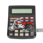 Calculator and toy motorbike isolated on white background