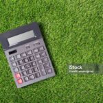 Calculator placed in green grass. Top of view