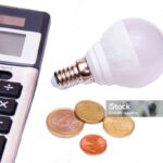 Energy saving light bulb and money on white background