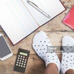 Selfie feet wearing white polka dot socks on wooden floor background