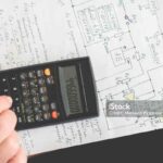 old man doing some math calculations using digital calculator at his work place