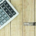 Calculator on wood pattern background, with copy space.