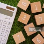 Calculation; Many wooden blocks of numbers and a white calculator.